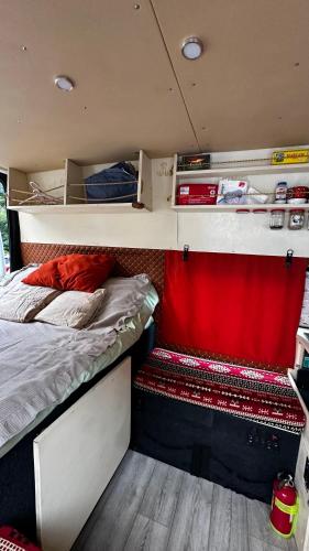 a small room with a bed and a red curtain at Ford Transit Motorhome-Camper in Batumi