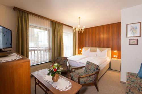 Una habitación de hotel con una cama, una mesa y sillas. en Ferienappartements Brandner, en Bad Hofgastein