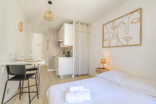 une chambre blanche avec un lit et un bureau dans l'établissement Verlaine-Tolstoi, à Villeurbanne