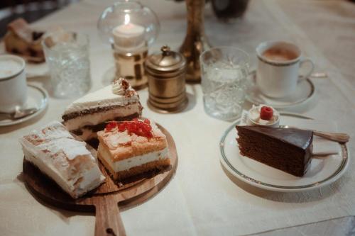 a table topped with different types of cakes on plates at Pension Mühlbacherhof in Mühlbach am Hochkönig