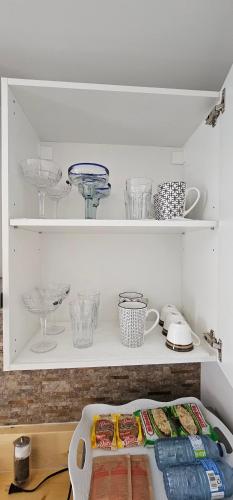 a shelf with bowls and other dishes on it at Cozy Retreat in Mission City