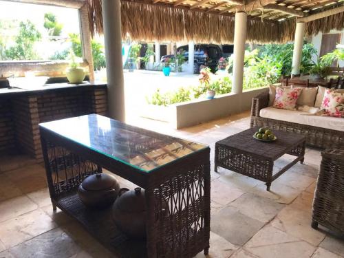 a patio with a table and a couch at Casa Cauipe Cumbuco in Paracumbuca