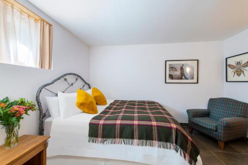 a bedroom with a bed and a chair at Chalet Balthazar 2 in Villars-sur-Ollon