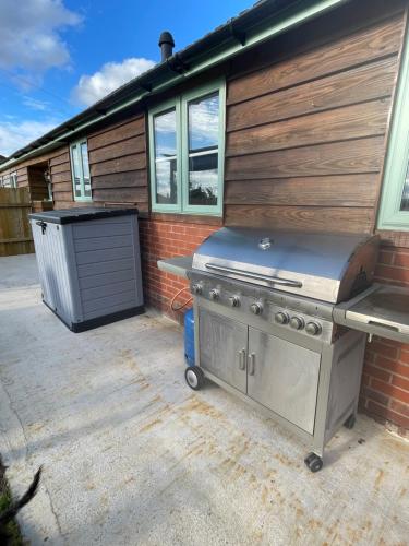a barbecue grill sitting outside of a house at Wisteria Barn hot tub holidays in the Cotswolds in Badsey