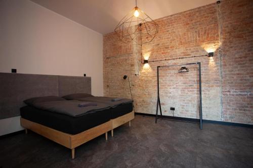 a bedroom with a bed and a brick wall at "Przy Rynku" pokoje z prywatnymi łazienkami in Gliwice