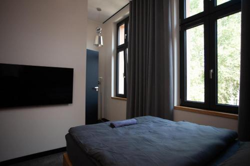 a bedroom with a bed and a flat screen tv at "Przy Rynku" pokoje z prywatnymi łazienkami in Gliwice