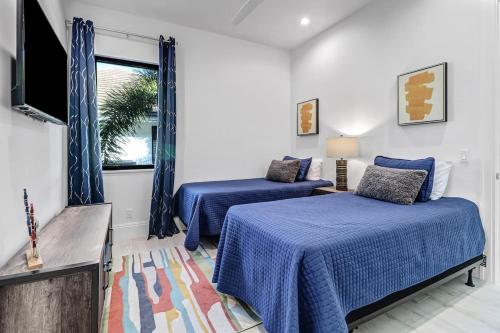 マルコ・アイランドにあるIsland Breeze Haven By Heat Propertiesのベッドルーム(ベッド2台、テレビ付)