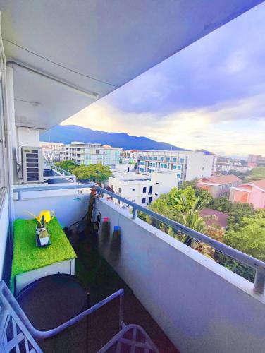 a balcony with a table and chairs and a view of a city at stay in style at nimman in Chiang Mai