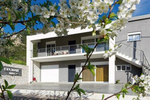 KandhílaにあるEva Mare Suitesのバルコニーと花木のある白い建物