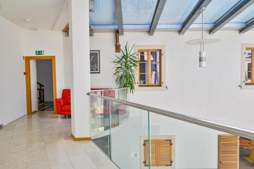 an open hallway with a staircase and a red chair at Hostel Sveta Ana in Koper