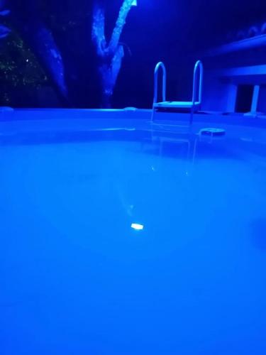 - un groupe de chaises dans une pièce dotée de lumières bleues dans l'établissement Appartement charmant à Alès | 62 m² | Piscine privée, à Alès