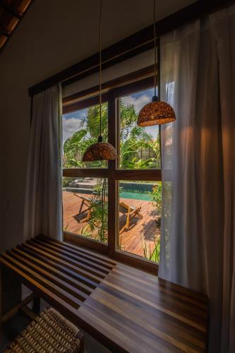 a room with a window with a bench and a view at Casa Teçá in Guriú