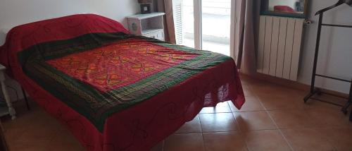 a bed with a red blanket on top of it at appartement T2 tout confort in Bastia