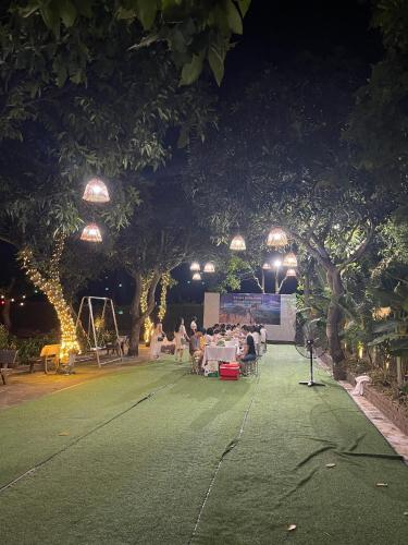 a group of people sitting on a tennis court at night at Hoa Lu Garden Resort in Ninh Binh