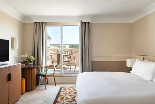 a hotel room with a bed and a large window at InterContinental Hotels Chantilly Chateau Mont Royal by IHG in Chantilly