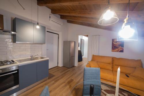 a kitchen and a living room with a couch at Abitare il Tempo-Elegante e Moderno-ad 1 bus da Roma in Velletri