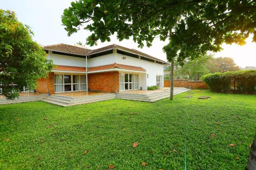a red brick house with a lawn in front of it at Super Townhouse Island Inn in Cochin