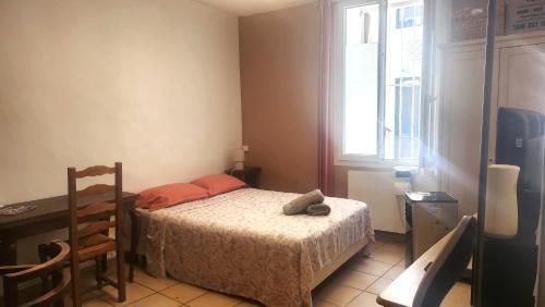 une chambre avec un lit, un bureau et une fenêtre dans l'établissement Escapade Paisible, Saint-Eugène, à Marseille