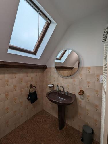 une salle de bain avec un lavabo, un miroir et une fenêtre dans l'établissement La maison de la Prade, classée 2 étoiles, linge founi, à Clairvaux-dʼAveyron