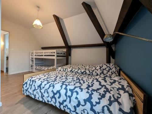 une chambre avec un lit avec une couette bleue et blanche dans l'établissement La maison de la Prade, classée 2 étoiles, linge founi, à Clairvaux-dʼAveyron