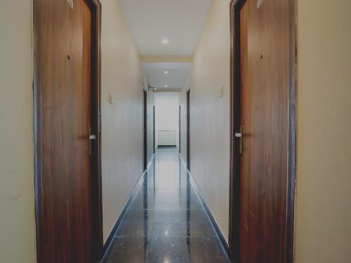 a hallway with two wooden doors and a long corridor at Super Hotel O Gokul Grand Near SR Nagar Police Station in Hyderabad