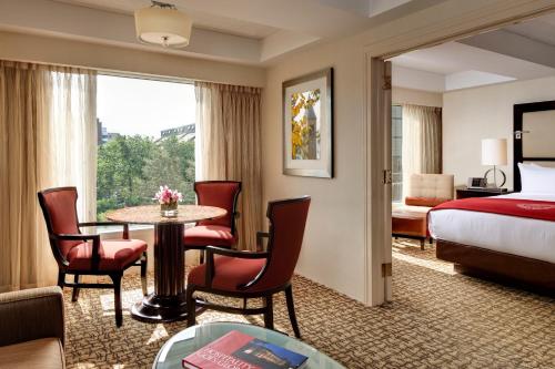 a hotel room with a bed and a table and chairs at The Statler Hotel at Cornell University in Ithaca