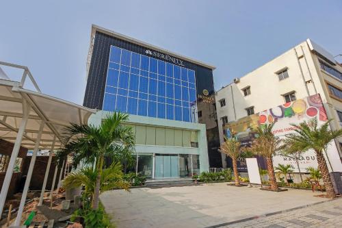 a tall building with palm trees in front of it at Capital O Hoysala Inn in Hyderabad
