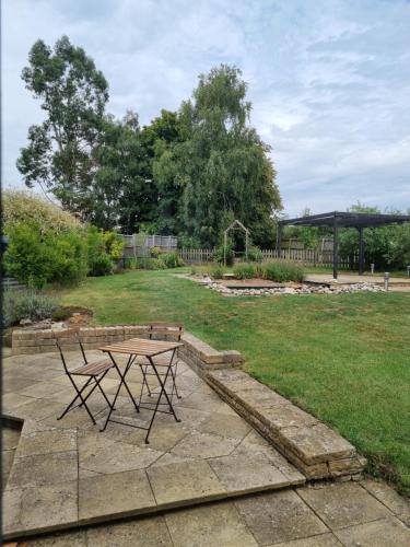 a picnic table and a bench in a yard at A quiet gem just outside Oundle in Oundle