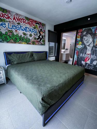 a bedroom with a large green bed with graffiti on the wall at Luxury Condo at Viva Jaco Residence in Jacó