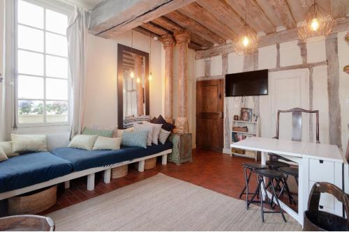 un salon avec un canapé bleu et une table dans l'établissement Appartement île Saint-Louis, à Paris