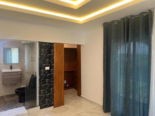 ein Badezimmer mit Toilette und Duschvorhang in der Unterkunft Nana's Duplex Apartment in Marshall