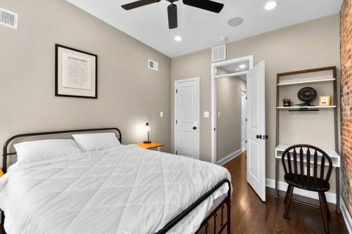 a bedroom with a bed with a ceiling fan and a chair at Federal Hill Luxury with Parking & Harbor View Rooftop in Fells Point