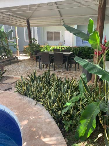 a patio with a table and chairs and plants at Villa Verde 2 Casa 14 in Tamarindo