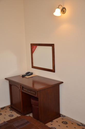 a wooden desk with a mirror on a wall at Hotel Restaurant La Conac in Botiz