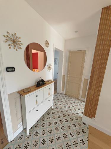 Cette chambre comprend une commode blanche et un miroir. dans l'établissement Appartement Cosy et accueillant, à Soissons