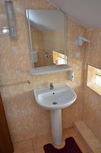 a bathroom with a sink and a mirror at Hotel Restaurant La Conac in Botiz