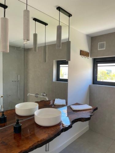 a bathroom with two sinks on a wooden counter at Casa Bordeira in Bordeira