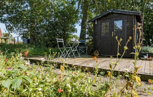 a wooden deck with a small shed in a garden at Cozy Home In Sydals With Sauna in Sarup