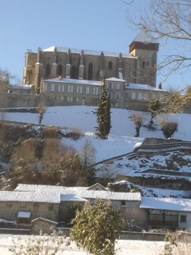 a large building with snow on the ground at Chez Anne et Christian in Saint-Bertrand-de-Comminges