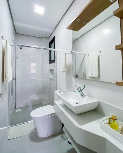 a bathroom with a sink and a toilet and a shower at Apartamento super completo a 250mts do mar in Governador Celso Ramos