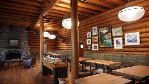 a restaurant with wooden walls and tables and a fireplace at The Lodge at Bow Lake in Lake Louise
