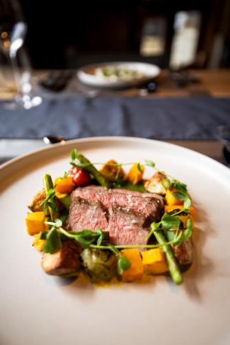 a plate of food with meat and vegetables on a table at The Lodge at Bow Lake in Lake Louise
