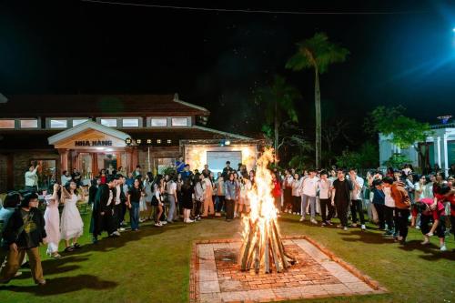 a crowd of people standing around a fire at Hoa Lu Garden Resort in Ninh Binh