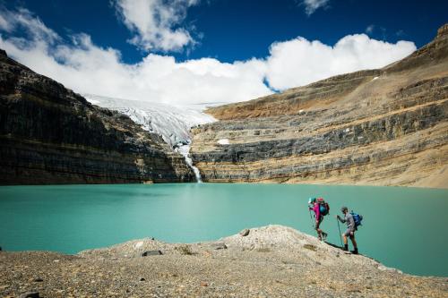two people standing in front of a mountain lake at The Lodge at Bow Lake in Lake Louise
