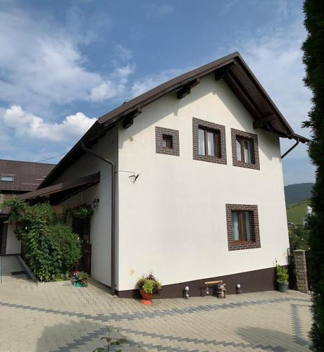 a white house with windows on the side of it at Casa de pe Deal in Sadova