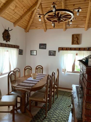 a dining room with a wooden table and chairs at Casa de pe Deal in Sadova