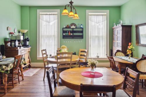 una sala da pranzo con pareti e tavoli e sedie verdi di Rustic Attic Room at Main Street Bed & Breakfast a Glasgow