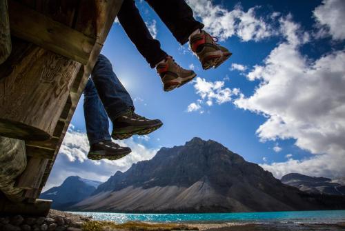 a person jumping in the air over a mountain at The Lodge at Bow Lake in Lake Louise