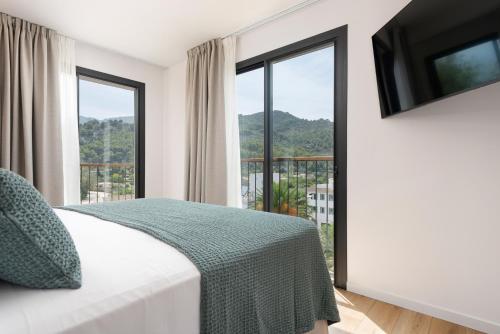 a bedroom with a bed and a large window at Repic Apartments Soller in Port de Soller