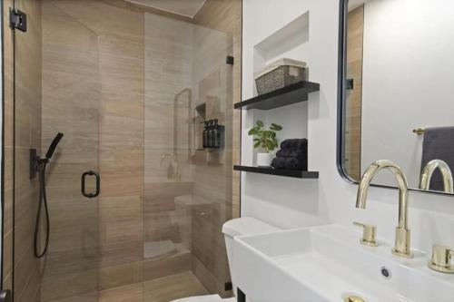 une salle de bains avec douche, lavabo et miroir dans l'établissement 5BD Home with outdoor space in Little Italy, à San Diego